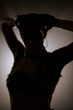 Şehvetli Latin dansçı dumanlı atmosferde dramatik ışıklandırma ile Latin dansına olan tutkusunu ve yeteneğini gösteriyor.