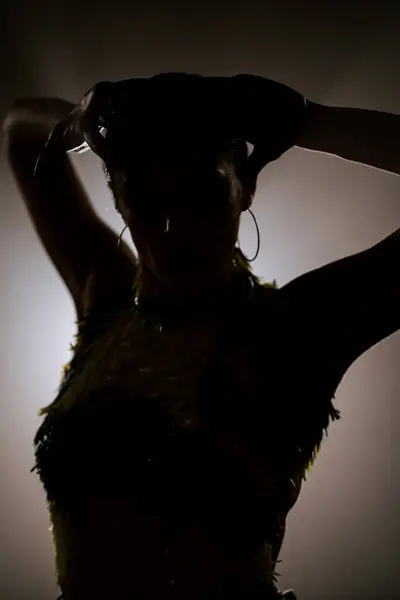 Şehvetli Latin dansçı dumanlı atmosferde dramatik ışıklandırma ile Latin dansına olan tutkusunu ve yeteneğini gösteriyor.