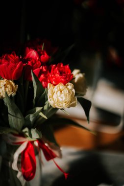 Temiz bir vazodaki parlak laleler güneşli bir odaya yansıyarak baharın gelişinin özünü yansıtıyor.