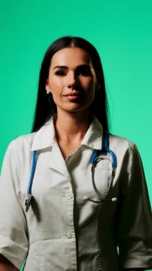 Doktor, profesyonel bir ortamda yeşil ekranlı bir akıllı telefon kullanarak tıbbi bilgileri gösteriyor.
