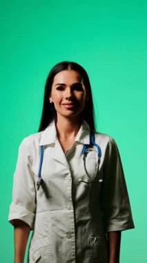 Doktor, profesyonel bir ortamda yeşil ekranlı bir akıllı telefon kullanarak tıbbi bilgileri gösteriyor.