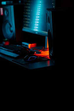 Bir bilgisayar faresi ve klavyeyi koyu ışıkta gösteren neon aksanlı oyun ayarları