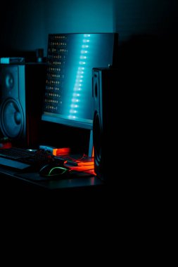 Bir bilgisayar faresi ve klavyeyi koyu ışıkta gösteren neon aksanlı oyun ayarları