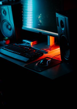 Bir bilgisayar faresi ve klavyeyi koyu ışıkta gösteren neon aksanlı oyun ayarları