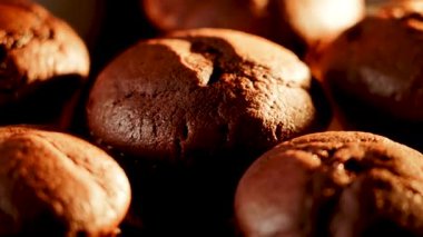 Çikolatalı kekler, sıcak ışığın aydınlattığı karanlık bir zemine doğru nazikçe dönüyorlar.