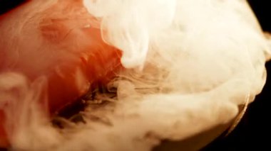 Baharatlı alabalık filetosu canlı renkler ve dokular içeren siyah bir yüzey üzerinde döner