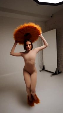 Moda modeli, modern bir stüdyo ortamında yaratıcı ve stil gösteren canlı sarı bir şapka takıyor.