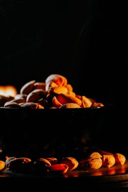 Sıcak kavrulmuş şam fıstığı, dumanlı bir kasede yükseliyor, dışarıda sıcak bir atıştırma anı sergiliyor.