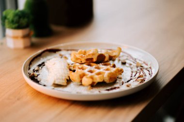 Sıcak bir kafe ortamında muzlu Belçika wafflelarının tadını çıkarıyorum.