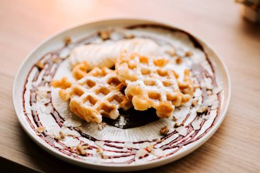 Sıcak bir kafe ortamında yeni yapılmış Belçika wafflelarının tadını çıkarıyorum.