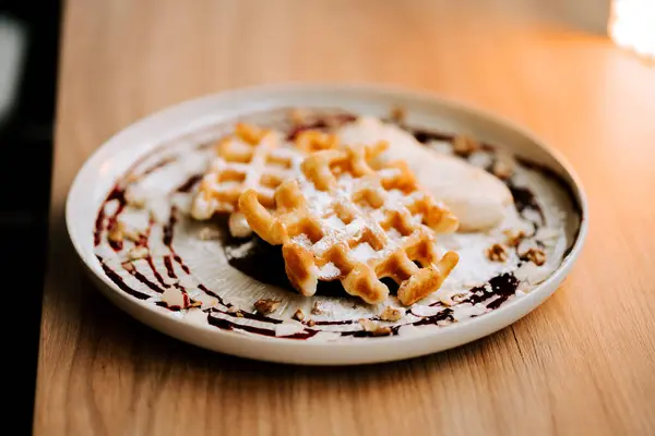Sabah kahvaltısı sırasında sıcak bir kafede taze yapılmış Belçika waffle 'larının tadını çıkarıyorum.