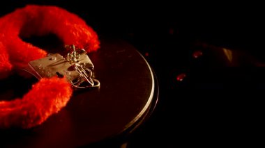 Karanlık bir yüzeyde canlı kırmızı bir dizayn ile dönen kelepçeler.