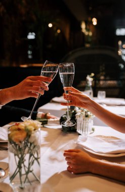 Parlak detaylarla süslenmiş zarif bir gelinlik ve yumuşak ışıkta yakalanmış çarpıcı bir yüzük.