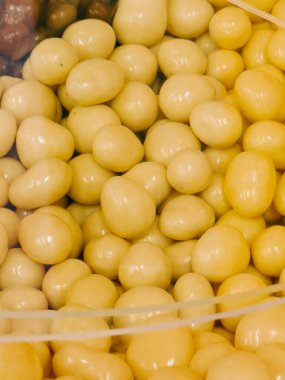 Nefis karamel küpleri ve kavrulmuş kahve çekirdekleri şeffaf bir kabın içinde sergileniyor.