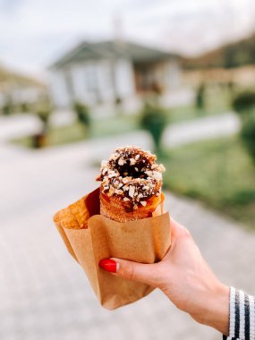 Öğleden sonra açık havada nefis bir tatlıyı tutarken.