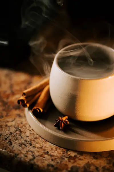 Evde sıcak bir akşamda tarçınlı sıcak bir kahvenin tadını çıkarıyorum.