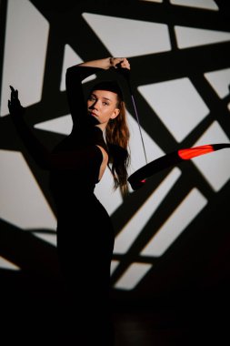 Hareket halindeki esneklik ve zarafeti gösteren bir kadının ritmik jimnastik performansı