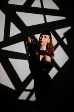 Ritmik jimnastik sanatçısı gölgelere karşı marifetli hareketler sergiliyor.