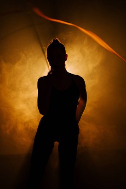 Kadın dramatik bir performans sırasında ritmik jimnastikte esneklik ve beceri sergiliyor