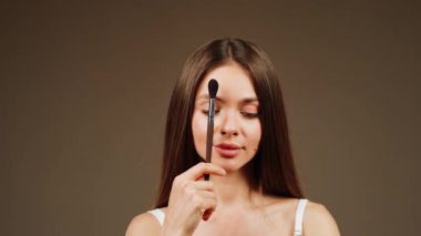 Güzellik yeteneklerini sergilemek için makyaj yapan bir kadın.