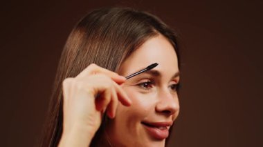 Sıcak bir stüdyo ortamında parlak bir görünüm için kaşlarını fırçalıyorsun.