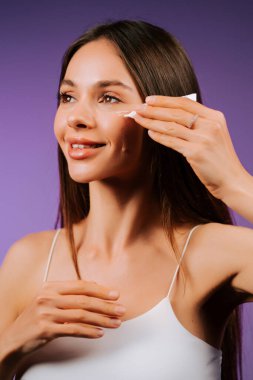 Cilt bakımı rutini. Bir kadın nazikçe yüzüne pamuk pedi sürüyor.