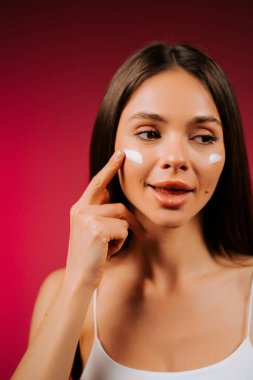 Cilt bakımı rutini. Yüzüne krem süren bir kadın.