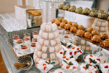 Lüks bir etkinlikte gösterişli bir tatlı gösterisi. Makaronlar ve meyve salatası.