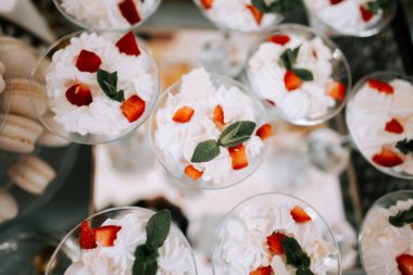 Şenlikli bir toplantıda sunulan krem şanti ve çilekle taze tatlılar