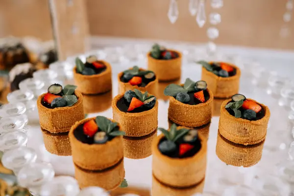 Şenlikli bir etkinlikte taze meyveli mini tatlı fincanları zarif bir şekilde sergileniyor.