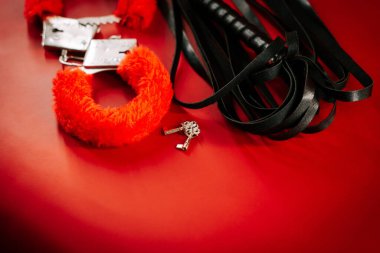 BDSM oyuncaklarının çeşitliliği keşif ve oyun için canlı kırmızı bir arkaplan üzerinde düzenlenmiştir