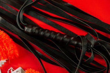 BDSM oyuncakları, yetişkinler için çeşitli dokular içeren parlak kırmızı bir arka planda sergilendi