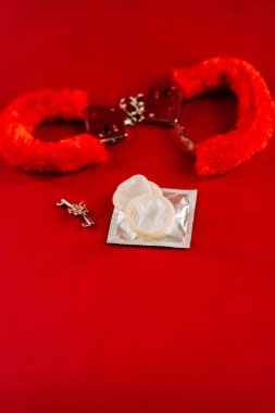 BDSM oyuncakları canlı kırmızı bir arkaplan üzerinde düzenlenmiş oyuncu ve maceracı temaları sergiliyor