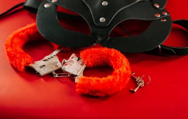 BDSM oyuncakları canlı kırmızı bir zemin üzerinde düzenlenmiş arzuların eğlenceli bir keşfi için