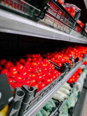 Markette sergilenen parlak kırmızı domatesler.