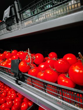 Taze domatesler gün boyunca süpermarket raflarında düzgünce dizildi.