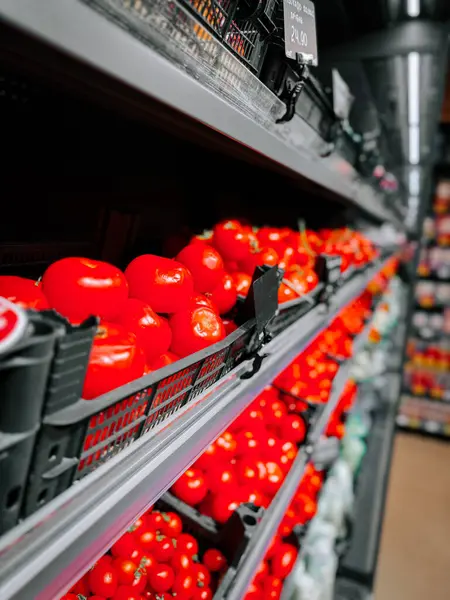 Gündüz saatlerinde süpermarket raflarında dizilmiş taze kırmızı domatesler.