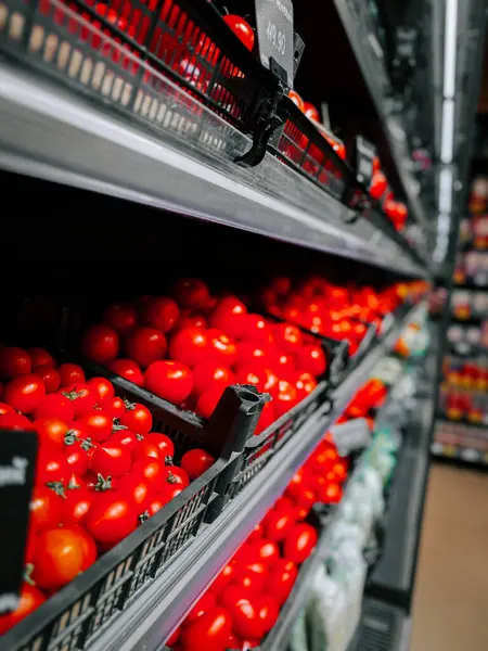 Taze kırmızı domatesler bir marketin raflarında güzelce dizilmiş.