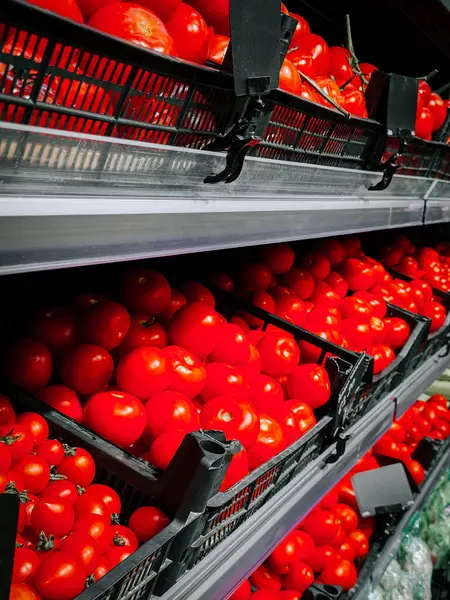 Taze kırmızı domatesler bir markette sepetlerin içinde düzgünce dizilmiş.