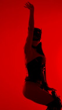 Dansçı, çarpıcı kırmızı neon ışıklar altında kedi kostümüyle yaratıcılığını sergiliyor