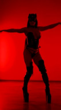 Kedi kostümlü dansçı kırmızı neon ışıkların altında poz verdi