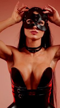 Kedi kostümlü kadın dansçı kırmızı neon ışığın altında zarafet ve zarafet sergiliyor.