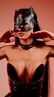 Kedi kostümlü kadın dansçı canlı kırmızı neon ışığın altında poz veriyor.