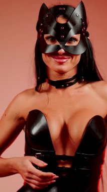 Kedi kostümlü kadın dansçı gece vakti canlı kırmızı neon ışıklar altında poz verir.