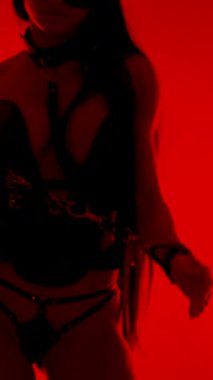 Kedi maskeli ve kelepçeli dansçı stüdyo ortamında eşsiz bir performans sergiliyor.