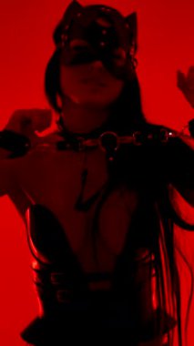 Dansçı, canlı bir stüdyoda kedi maskesi ve kelepçe takıyor.