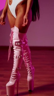 Grevdeki beyaz elbiseli dansçı ve kedi maskeli dansçı canlı pembe arka planda gösteri yapıyor