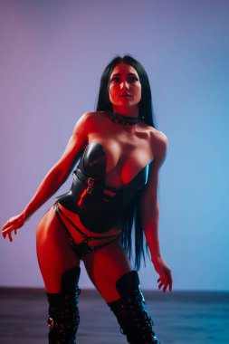 Dramatik ışıklandırma gösterisi sırasında çarpıcı giyimli bir modelin performans sanatı