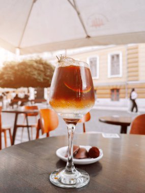 Açık bir kafede limonlu ve buzlu soğuk kahvenin tadını çıkarıyorum.