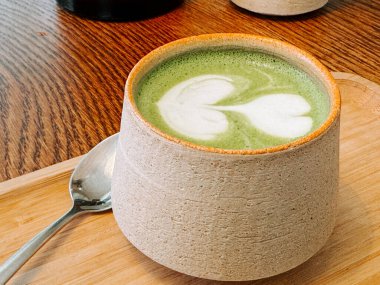 Hoş bir kafe ortamında latte sanatıyla nefis bir eşleşmenin tadını çıkarıyorum.